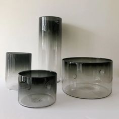 three glass vases sitting next to each other on top of a white countertop