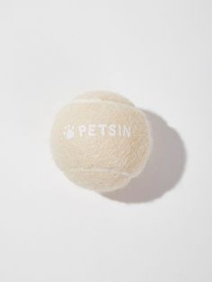 a white tennis ball with the word petsin written on it's side, sitting on a white surface