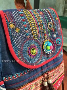 an embroidered purse with tassels and beads on it