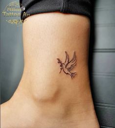 a small bird tattoo on the side of a woman's lower back ribcage