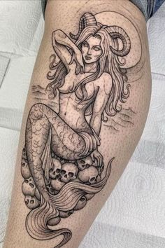 a woman is sitting on top of a mermaid with skulls in her hair and skull head tattoos