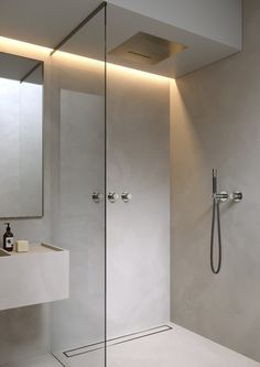 a bathroom with a shower, sink and mirror