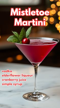 a red drink in a martini glass with a green garnish