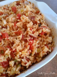 rice and vegetables are mixed together in a white casserole dish on a table