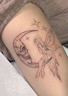 a tattoo with a fairy sitting on the moon next to a human skull and stars