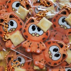 many orange and white tiger shaped cookies in plastic bags with beaded necklaces on them