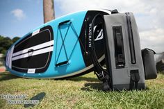 a blue and black kayak sitting on top of grass next to a pole in the background