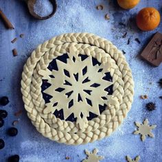 a cookie decorated with an intricate snowflake design surrounded by cookies and other decorations