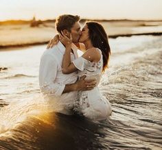 a man and woman are kissing in the water