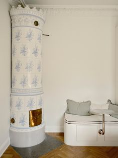 a room with a white and blue fireplace next to a bed on a wooden floor