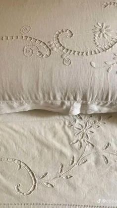 two white pillows sitting next to each other on top of a bed