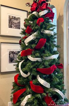 a christmas tree decorated with red and white ribbons