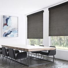 a dining room table and chairs in front of two windows with roman shades on them