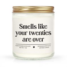 a candle that says smells like your twenties are over on the front and back of it