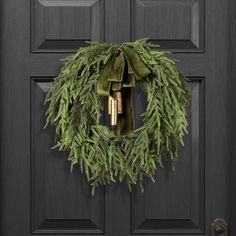 a wreath with bells hanging on the front door