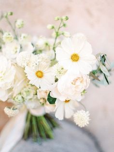 a vase filled with white flowers on top of a table