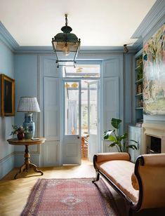 a living room filled with furniture and a rug on top of a hard wood floor