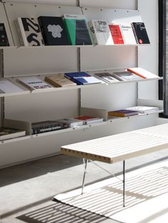 a white table sitting in front of a book shelf filled with books