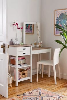 a white desk with a mirror, chair and potted plant on top of it