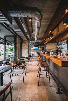 an empty restaurant with lots of chairs and tables next to the bar, looking out onto the water