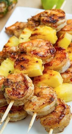 grilled shrimp and pineapple skewers with toothpicks on a white plate