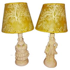 two lamps that are next to each other on a white surface and one has a yellow shade