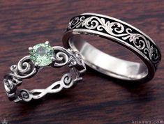 two wedding rings with an aqua green stone in the center and filigrees on each side