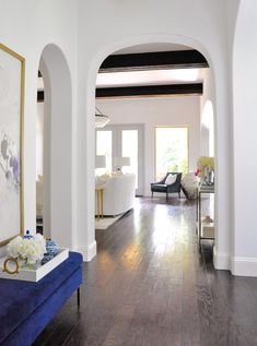 a living room filled with furniture and a painting on top of a hard wood floor