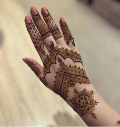 a woman's hand with henna tattoos on it