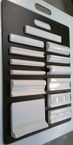 a black and white wall mounted display with many different items on it's side