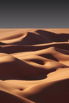 sand dunes in the desert with no one on them or people walking along side it