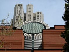 a large building with a clock on it's face and some buildings in the background