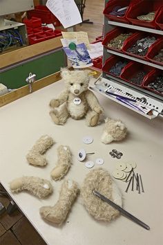 a teddy bear sitting on top of a table next to buttons and other crafting supplies