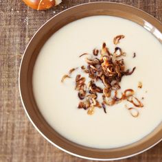 a bowl filled with milk and nuts on top of a table