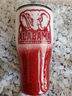 a red and white tumbler sitting on top of a carpet