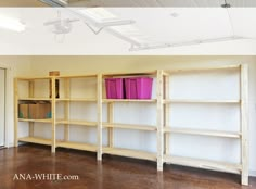 an empty room with shelves and bins in it