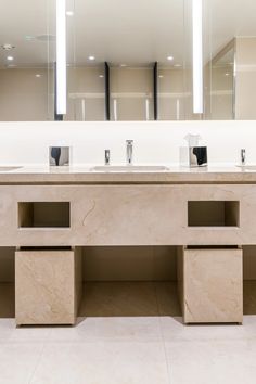 a bathroom with two sinks and mirrors on the wall next to each other in front of a large mirror