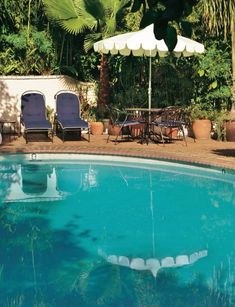 a pool with chairs and an umbrella next to it