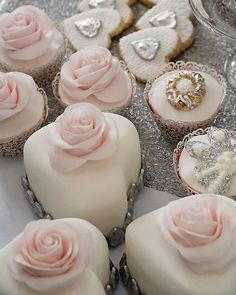 there are many cupcakes with pink frosting on the top and one is decorated with roses