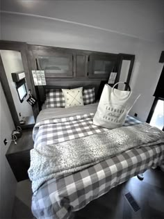 a bed with a checkered comforter and pillows on top of it in a bedroom