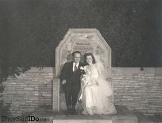 an old black and white photo of a bride and groom standing in front of a memorial