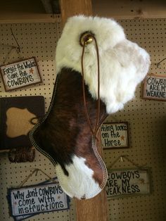 a cowhide hanging on a wall in a store with other items behind it and signs