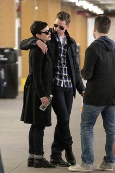 two people standing next to each other in an airport