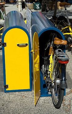 a bike parked next to a yellow and blue portable toilet