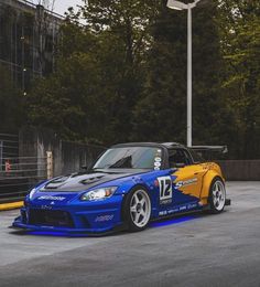 a blue and yellow car parked in a parking lot