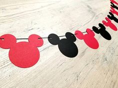 a mickey mouse party banner with red and black paper cutouts hanging on a string