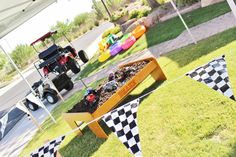 an outdoor area with flags and cars on the grass, in front of a golf cart