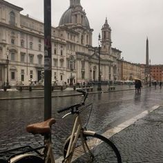 a bicycle parked on the side of a wet street