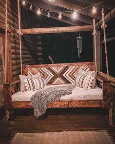 a bed that is made out of wood and has some pillows on top of it