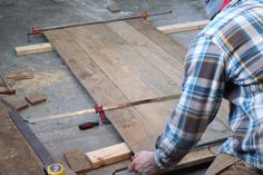 a man is working on some wood planks